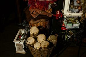 invierno en rústico interior. registros para chimenea, conjunto de acogedor mantas, de madera caja con Navidad adornos Navidad guirnalda y envuelto presente. acogedor escena, oscuro antecedentes foto