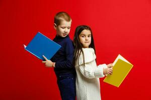 Little children with books isolated on red photo