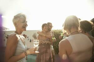 hembra y masculino amigos disfrutando verano mientras Bebiendo alcohol en contra cielo foto