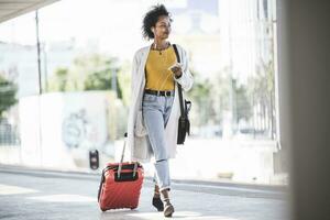 Young woman with cell phone and earphones at the train station photo