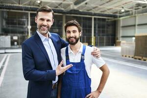 retrato de contento empresario y trabajador en un fábrica foto