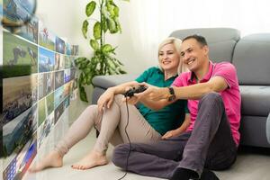 Beautiful couple playing video games on a huge screen photo