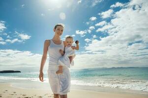 madre caminando con pequeño hija en el playa foto