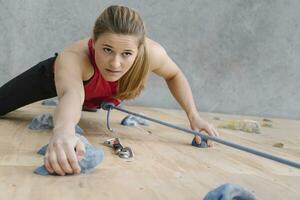 Woman climbing on the wall in climbing gym photo