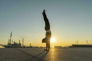 Acrobat doing handstand in the city at sunrise photo