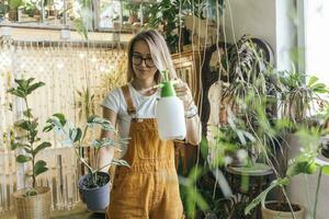 Young woman caring for plants in a small shop photo