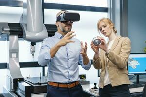 Businessman and businesswoman withVR glasses and workpiece in factory photo