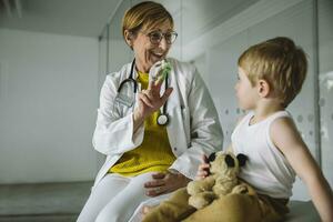 Peditrician with finger dolls and toddler in medical practice photo