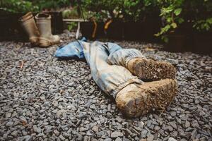 Deferred pair of dirty childish gumboots with mud after the day in forest kindergarten laying on the ground with another pair of gumboots in background photo