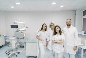 grupo de dentistas en pie en clínica foto