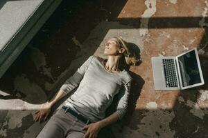 Woman sleeping on the floor next to laptop photo