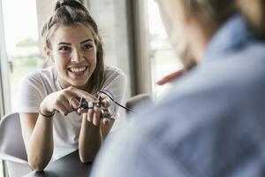 Happy young woman and man working on computer equipment in office photo