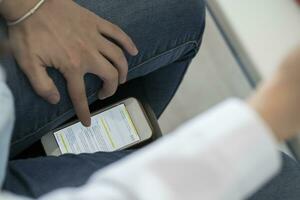 Crop view of student scrolling smartphone trying to copy an exam photo