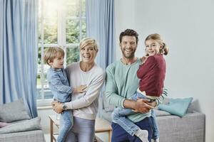 retrato de contento familia con dos niños a hogar foto