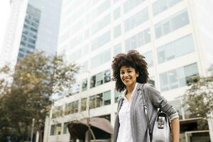 Portrait of smiling woman with bag outdoors photo