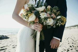 Bridal couple with bridal bouquet at the beach photo