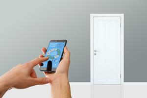 smart house, home automation, device with app icons. Man uses his smartphone with smarthome security app to unlock the door of his house. photo