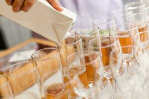 Juice is poured from a pack into a glass. Waiter is pouring juice in a cafe, restaurant photo