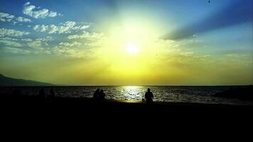 Menschen Silhouette in der Nähe des Meeres bei Sonnenuntergang video