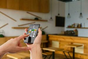 smart house, home automation, device with app icons. Man uses his smartphone with smarthome security app to unlock the door of his house. photo