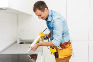 Young Repairman Installing Induction Cooker In Kitchen photo