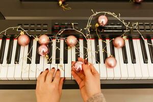 cerca arriba humano manos jugando piano en Navidad fiesta foto