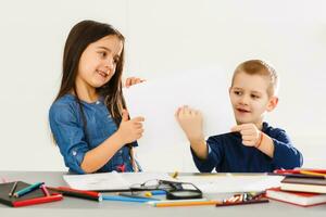 dos linda sonriente Niños de escuela con blanco sábana de papel en manos foto