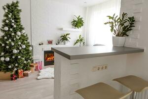 Fireplace and Christmas tree with presents in living room photo