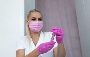 Mesotherapy And Microneedling Beauty Procedure. Closeup Real Female Aesthetician Holds Dermapen For Invasive Cosmetic Treatment Using Thin Needles. Microdermabrasion, Horizontal Plane photo