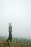 Cowboy Delight - Man in Mexican Hat and Boots amid Foggy Landscape photo