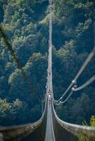 People while crossing the Tibetan bridge of Dossena.Which is the longest in the world photo