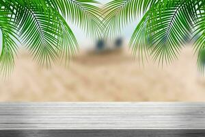 Summer tropical sea with waves, palm leaves and blue sky with clouds. Perfect vacation landscape with empty wooden table photo