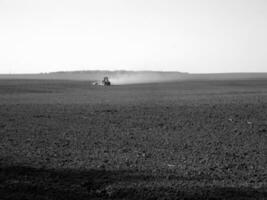 Plowed field by tractor in black soil on open countryside nature photo