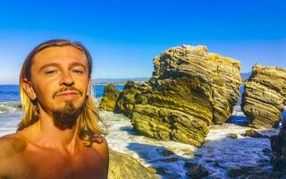 Selfie with rocks cliffs view waves beach Puerto Escondido Mexico. photo