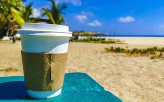 Coffee to go mug on the beach sand sea waves. photo