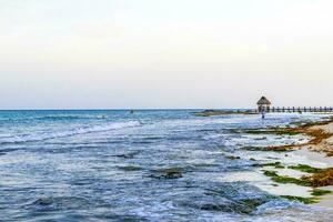 Tropical Caribbean beach clear turquoise water jetty Playa Xcalacoco Mexico. photo