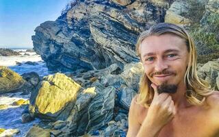 Selfie with rocks cliffs view waves beach Puerto Escondido Mexico. photo