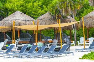 Palapa thatched roofs palms parasols sun loungers beach resort Mexico. photo