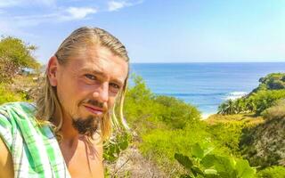 Selfie with rocks cliffs view waves beach Puerto Escondido Mexico. photo