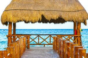 Tropical Caribbean beach clear turquoise water jetty Playa Xcalacoco Mexico. photo