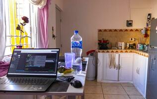 Playa del Carmen Quintana Roo Mexico 2021 Laptop work at table with coffee cup in Mexico. photo