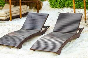 Palapa thatched roofs palms parasols sun loungers beach resort Mexico. photo