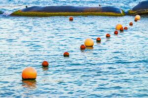 Blue water waves ocean with buoy buoys ropes nets Mexico. photo