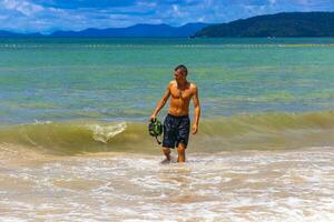 Male handsome tourist swimming having fun Railay West Beach Thailand. photo