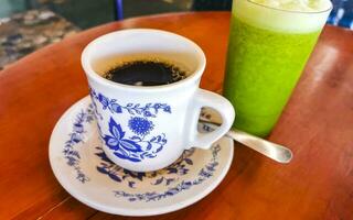 Blue white cup pot with black coffee green smoothie Mexico. photo