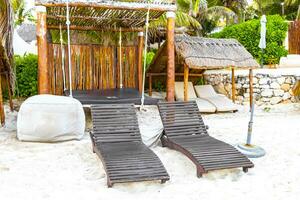 Palapa thatched roofs palms parasols sun loungers beach resort Mexico. photo