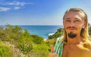 Selfie with rocks cliffs view waves beach Puerto Escondido Mexico. photo