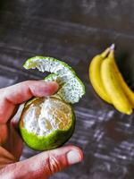 Hands peel a green orange citrus fruit in Mexico. photo