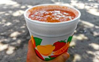 Orange multi vitamin fruit juice in take away cup Mexico. photo