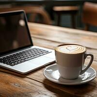 Coffee and laptop on a wooden table photo